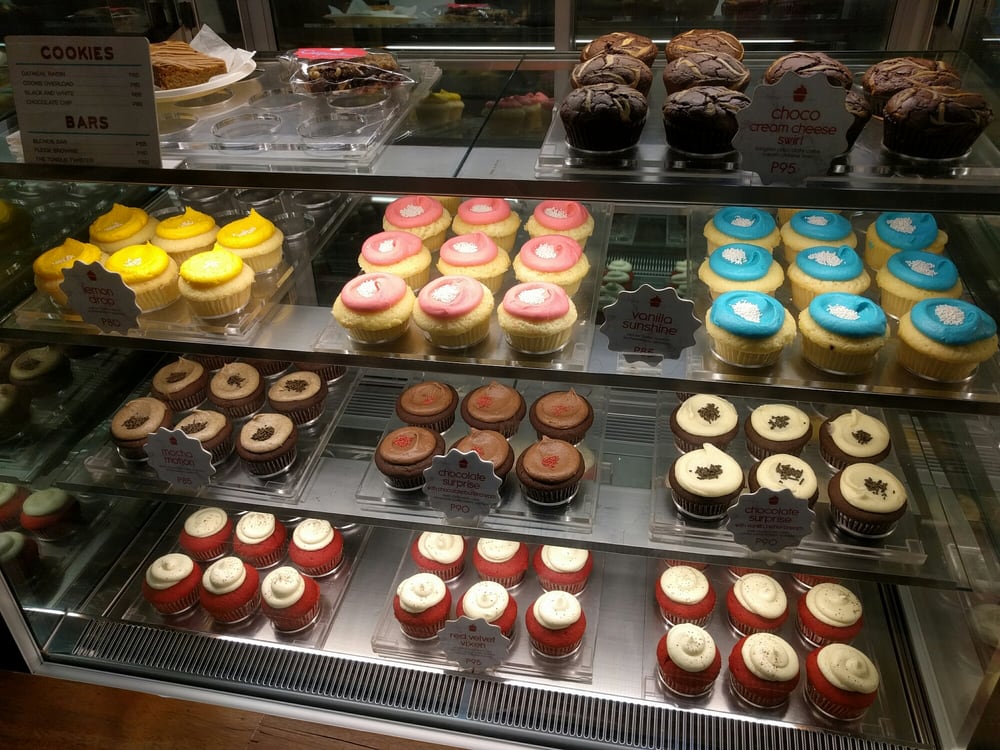 Colorful cupcakes display - lemon drop, vanilla sunshine, red velvet, and chocolate varieties